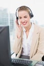 Smiling pretty agent wearing headset dealing with customer Royalty Free Stock Photo