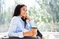 Smiling pretty black business woman relax with cup of coffee in hand during break time in modern office Royalty Free Stock Photo