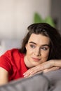 Smiling pretty young woman wearing casual clothes relaxing on a couch at home Royalty Free Stock Photo