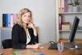 smiling pretty businesswoman using laptop and computer while doing some paperwork at the office Royalty Free Stock Photo