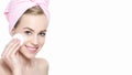 Smiling pretty girl with perfect complexion cleansing her face using soft cosmetic cotton pad Royalty Free Stock Photo