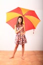 Smiling pretty girl with red and yellow umbrella Royalty Free Stock Photo