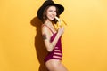 Smiling pretty girl in summer hat and swimsuit holding banana Royalty Free Stock Photo