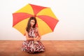 Smiling pretty girl under red and yellow umbrella Royalty Free Stock Photo