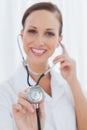 Smiling pretty nurse posing holding her stethoscope Royalty Free Stock Photo