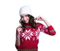 Smiling pretty young woman wearing colorful knitted sweater with christmas ornament and hat. Isolated on white background. Royalty Free Stock Photo