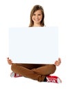 Smiling pretty teenager posing with blank placard Royalty Free Stock Photo