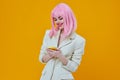 smiling pretty woman pink wig suit phone technology Royalty Free Stock Photo