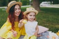 Smiling pretty woman play on green grass in park rest, have fun with little cute child baby girl hold soap bubble blower Royalty Free Stock Photo