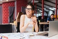 Smiling pretty young business woman in glasses sitting on workplace Royalty Free Stock Photo