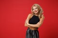 Smiling pretty young woman girl in black clothes posing isolated on bright red wall background studio portrait. People Royalty Free Stock Photo