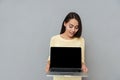 Smiling pretty young woman holding blank screen laptop Royalty Free Stock Photo