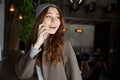 Smiling pretty young woman talking on cell phone in cafe Royalty Free Stock Photo