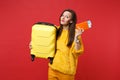 Smiling pretty young woman in yellow fur sweater holding suitcase, passport boarding pass ticket isolated on bright red Royalty Free Stock Photo