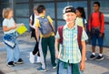 Smiling primary school boy standing outdoors