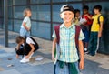 Smiling primary school boy standing outdoors