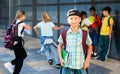 Smiling primary school boy standing outdoors