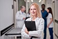 Smiling Professional Female Doctor Posing At Camera Holding Clipboard in Hands Royalty Free Stock Photo