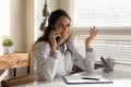 Smiling professional female doctor talking on phone, consulting patient Royalty Free Stock Photo
