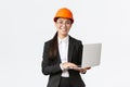 Smiling professional female saleswoman showing construction works on new house. Asian industrial engineer in safety Royalty Free Stock Photo