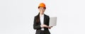 Smiling professional female saleswoman showing construction works on new house. Asian industrial engineer in safety Royalty Free Stock Photo