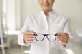 Smiling professional optician willing to help and asking you to try on new glasses Royalty Free Stock Photo