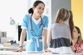 Smiling professional pediatrician talk to young cute patient girl on appointment