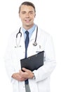 Smiling professional physician carrying clipboard