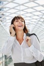 Smiling professional woman talking on smart phone in station Royalty Free Stock Photo