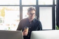 Smiling programmer with coffee to go