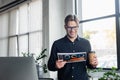 Smiling programmer holding paper and coffee