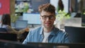 Smiling programmer working computer corporate workplace closeup. Man looking pc