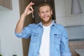 Smiling proud young man renter first time estate owner holding key to new home. Royalty Free Stock Photo