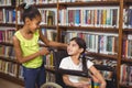 Smiling pupil in wheelchair holding books in the library