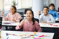 Smiling pupils taking off disposable medical mask at classroom Royalty Free Stock Photo