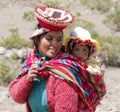 Smiling Quechua Woman Dressed In Colorful Traditional Handmade Outfit Carrying Her Baby In A Sling Royalty Free Stock Photo