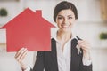 Smiling Realtor Holding Keys and Model of House. Royalty Free Stock Photo