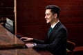 A smiling receptionist at his desk