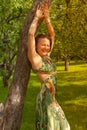 Smiling red-haired alternative girl with shaved walks in a Sunny Apple orchard on a Sunny summer day Royalty Free Stock Photo