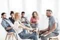 Smiling red-haired girl talking with therapist during meeting for difficult teenagers