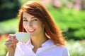 Smiling red headed woman cup coffee. Close-up portrait of young beautiful woman holding the cup of morning coffee over Royalty Free Stock Photo