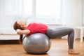 Smiling redhead girl exercising with fitness ball Royalty Free Stock Photo