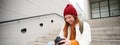 Smiling redhead girl photographer, checks her shots, holds camera and looks at screen, takes photos outdoors, walks