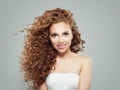 Smiling redhead woman with long healthy curly hair and clear skin. Cute girl on gray background Royalty Free Stock Photo