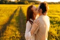 Smiling redhead young woman with closed eyes and unrecognizable man in love hugging, kissing, stroking standing together Royalty Free Stock Photo