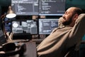 Smiling relaxed coder sitting laid back on chair