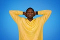 Smiling relaxed millennial african american guy in sweatshirt resting with closed eyes Royalty Free Stock Photo