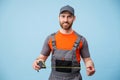 Smiling repairman worker in uniform holding measure tape on yellow studio background Royalty Free Stock Photo