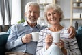 Smiling retired family spouses enjoying lazy weekend morning time.