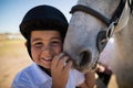 Smiling rider boy touching the white horse Royalty Free Stock Photo